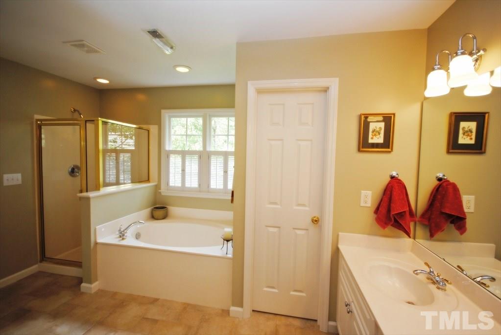 8805 Braceridge Road Raleigh, NC 27613 - Photo 21 of 25 a bathroom with a tub sink and mirror