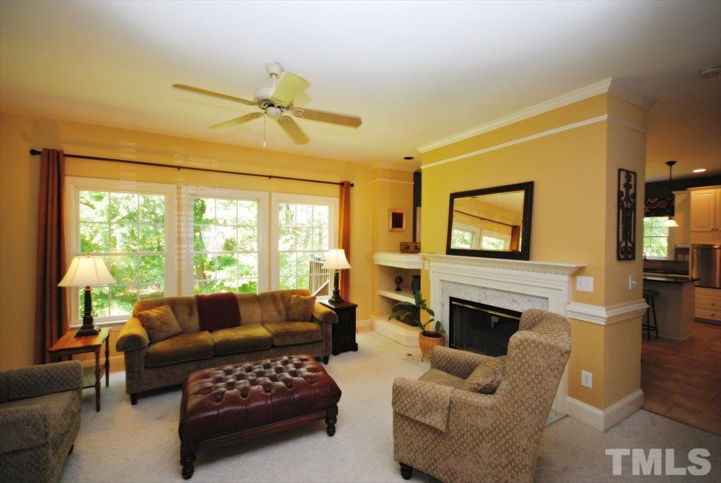 8805 Braceridge Road Raleigh, NC 27613 - Photo 8 of 25 a living room with furniture a fireplace and a flat screen tv