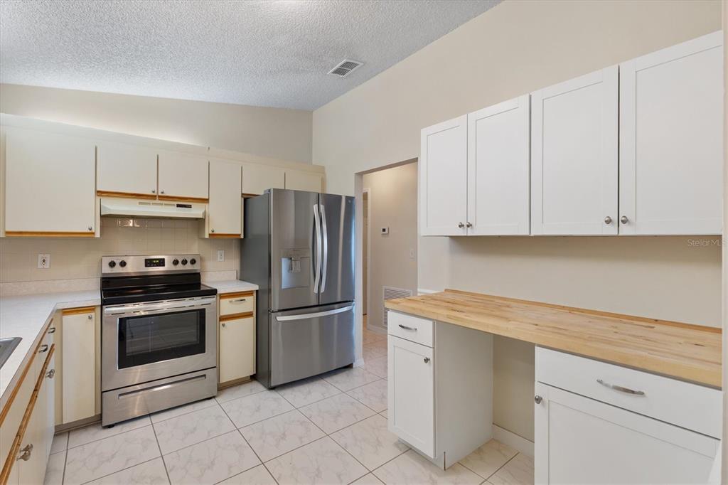 10767 Southeast 174th Loop Summerfield, FL 34491 - Photo 12 of 45 a kitchen with white cabinets and stainless steel appliances