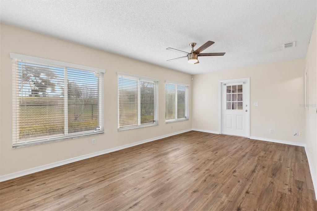 10767 Southeast 174th Loop Summerfield, FL 34491 - Photo 17 of 45 a view of an empty room with wooden floor and a window