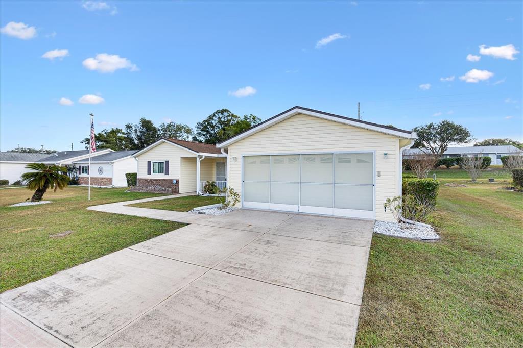 10767 Southeast 174th Loop Summerfield, FL 34491 - Photo 2 of 45 a front view of a house with a yard and garage