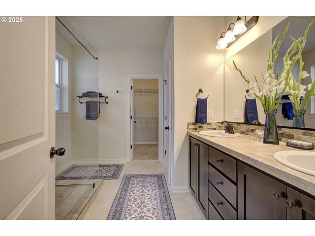 a bathroom with a granite countertop sink a mirror and shower