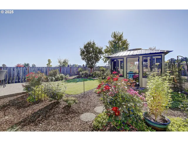 a view of a patio with table and chairs and wooden fence