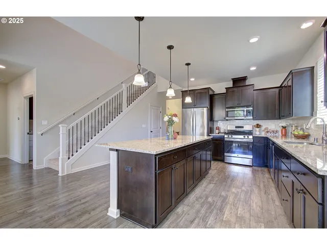 a kitchen with granite countertop stainless steel appliances a sink a counter top space cabinets and stainless steel appliances