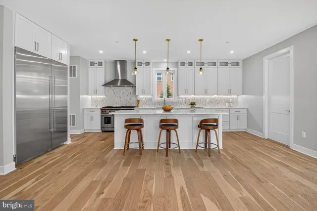 a large kitchen with stainless steel appliances kitchen island granite countertop a sink and a stove