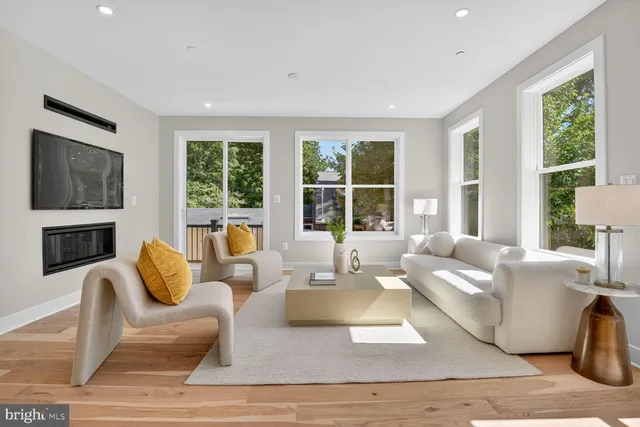 a living room with fireplace furniture and a large window
