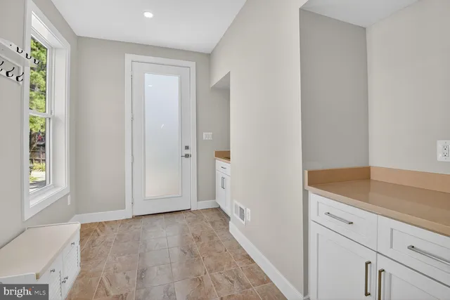 a view of a kitchen with white cabinets and wooden floor