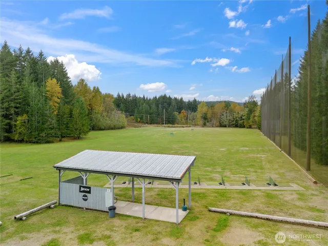 a view of a swimming pool with lawn chairs under an umbrella