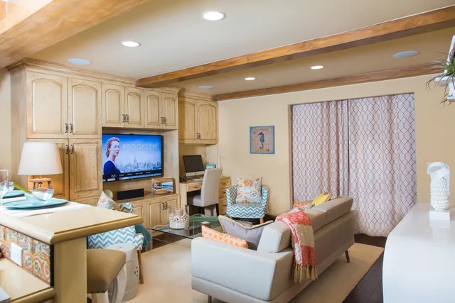 a living room with furniture a flat screen tv and kitchen view