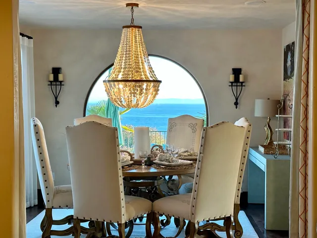 a dining room with furniture a chandelier and wooden floor