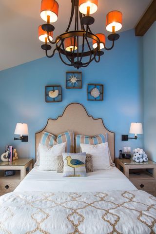 a bedroom with a bed mirror and lamp on dresser