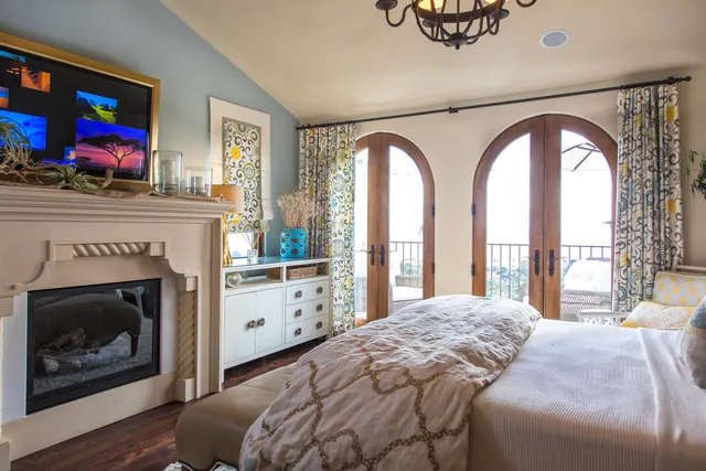 a bedroom with a bed a fireplace and a large window