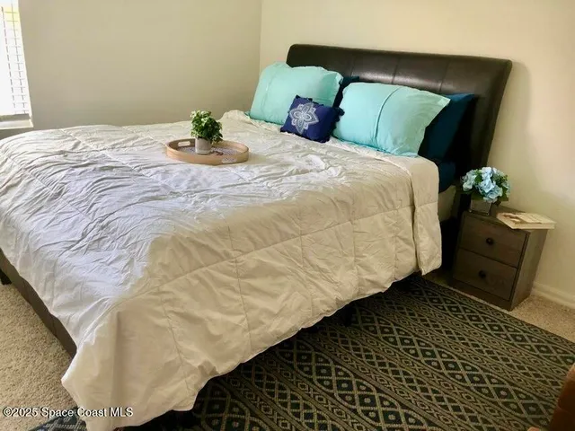 a bedroom with two bed and a painting on the wall