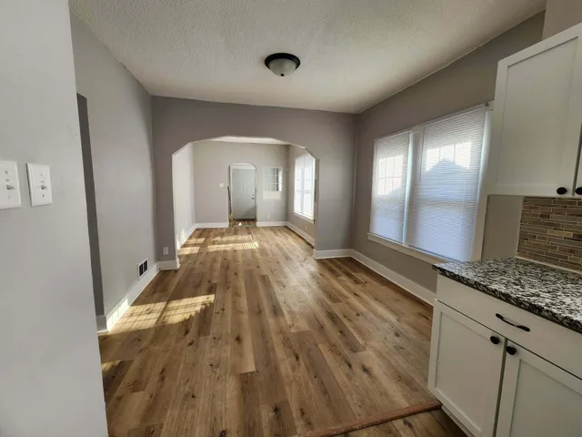 a spacious bathroom with a granite countertop sink and a mirror
