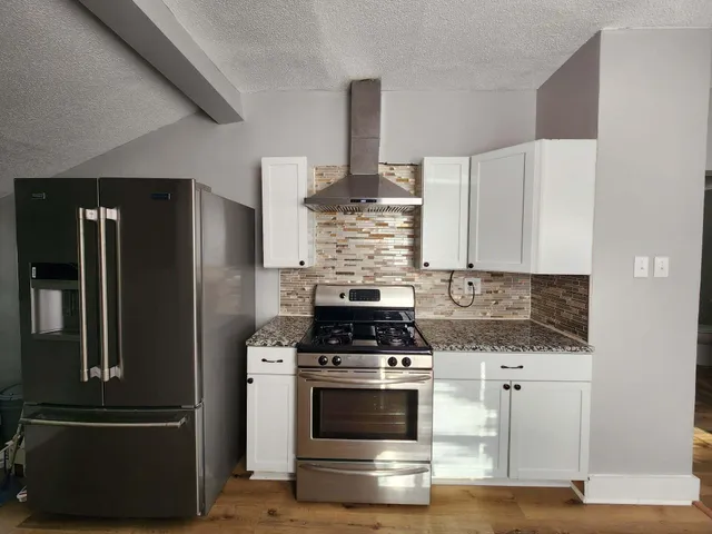 a kitchen with granite countertop a stove and a refrigerator