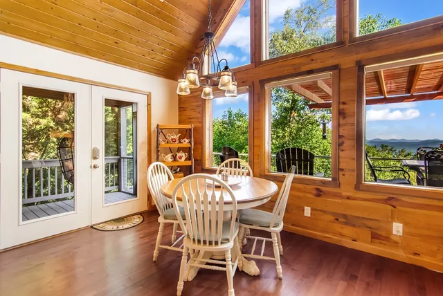 a view of a dining room with furniture a chandelier and wooden floor