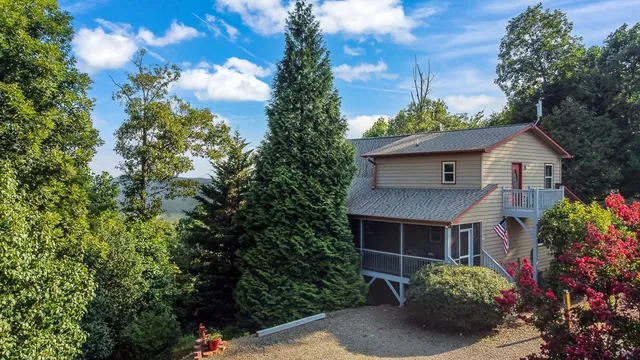 a front view of house with yard and trees in the background