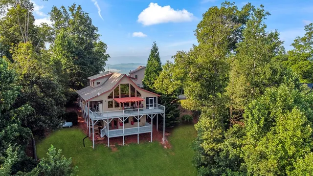 an aerial view of a house with a big yard and large trees