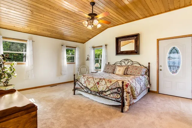 a spacious bedroom with a large bed and a chandelier