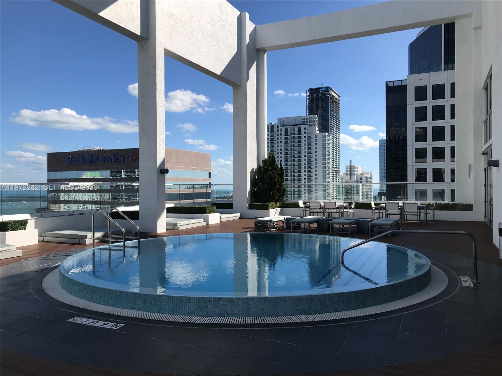 55 Southeast 6th Street, Unit 1201 Miami, FL 33131 - Photo 19 of 26 a view of a swimming pool with outdoor seating