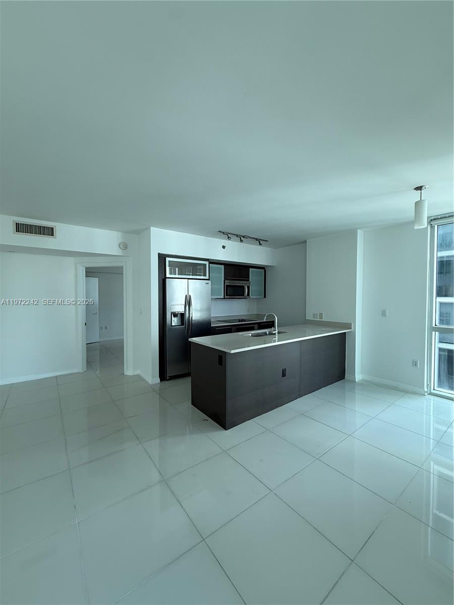 55 Southeast 6th Street, Unit 1201 Miami, FL 33131 - Photo 7 of 26 a large kitchen with stainless steel appliances a sink and cabinets