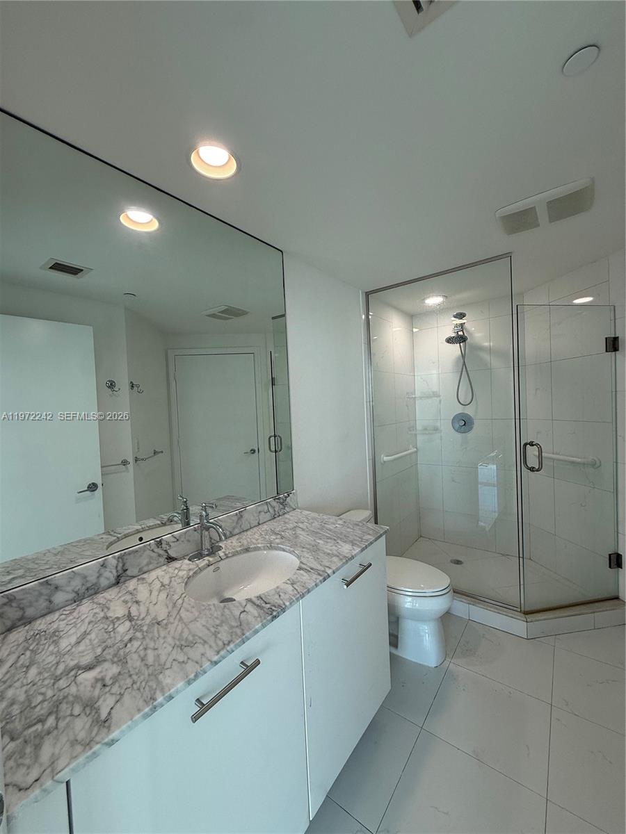 55 Southeast 6th Street, Unit 1201 Miami, FL 33131 - Photo 8 of 26 a bathroom with a granite countertop sink a toilet and shower