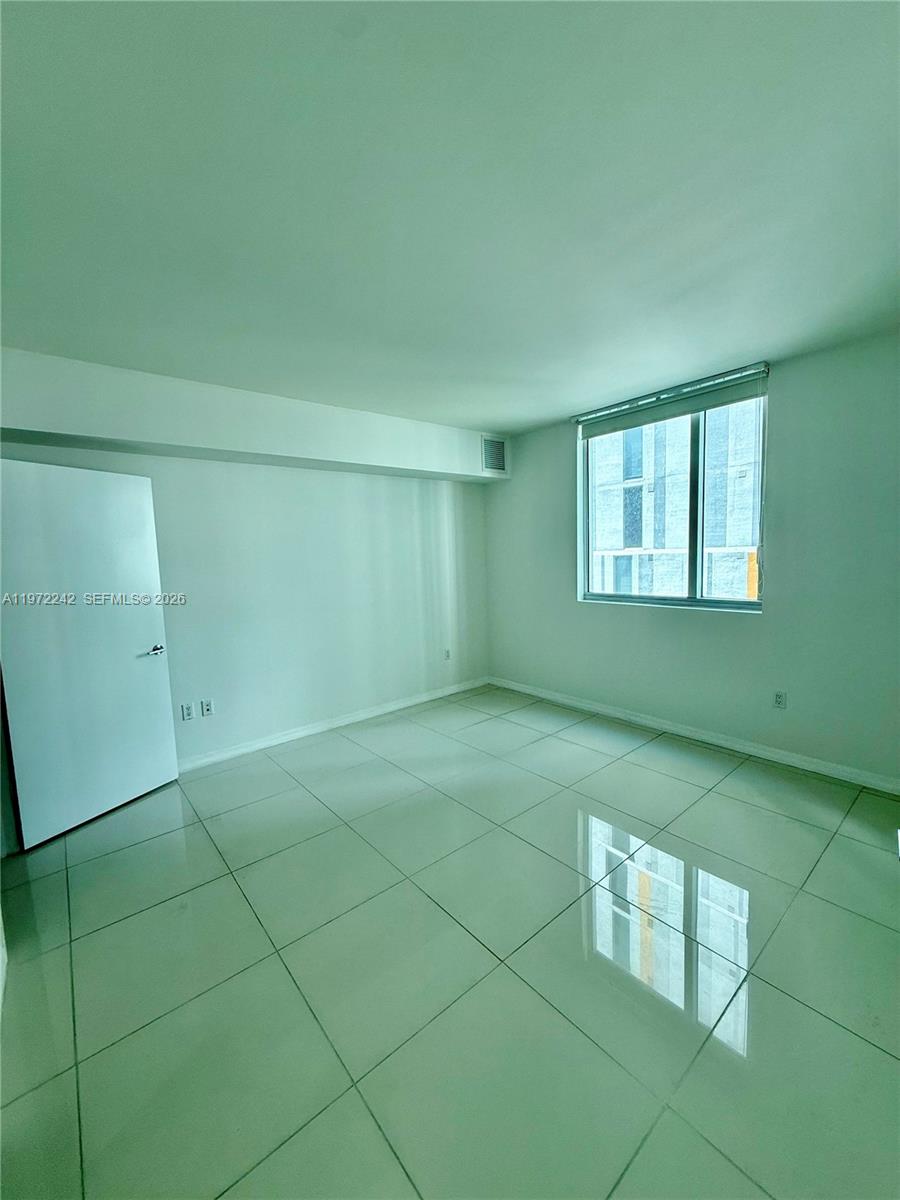 55 Southeast 6th Street, Unit 1201 Miami, FL 33131 - Photo 9 of 26 a room with a window and a chandelier