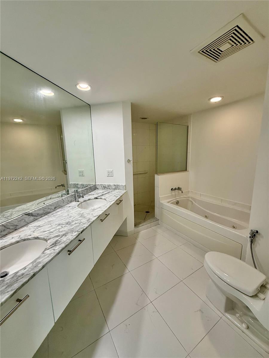 55 Southeast 6th Street, Unit 1201 Miami, FL 33131 - Photo 10 of 26 a bathroom with a granite countertop sink mirror vanity and toilet