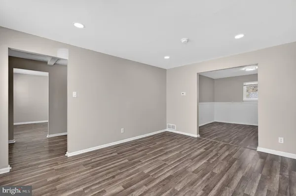 a view of an empty room with wooden floor and closet