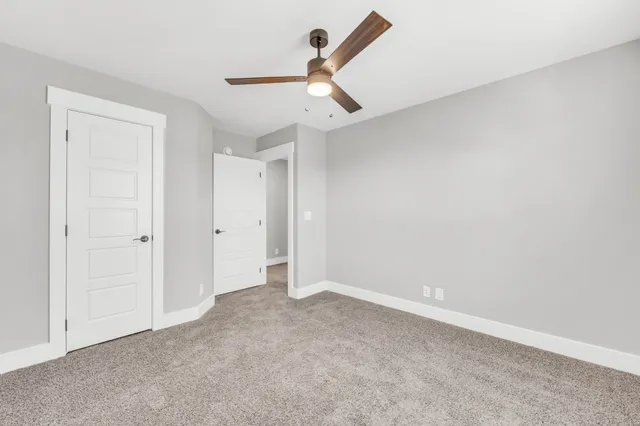 an empty room with a ceiling fan and a window