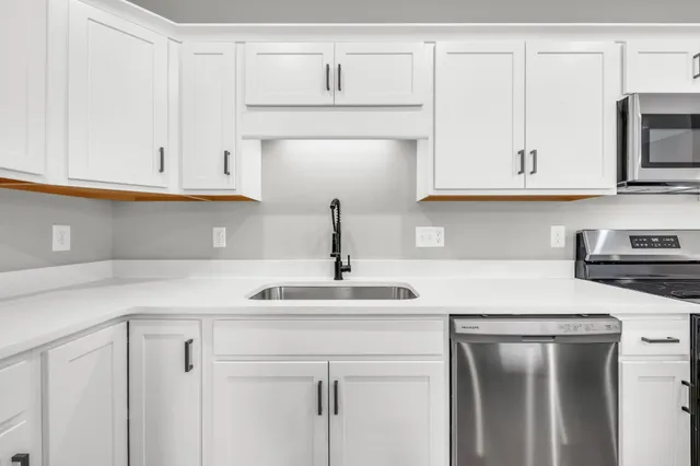 a kitchen with white cabinets and a sink