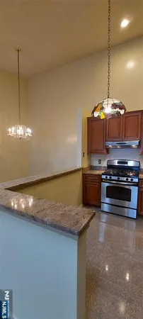 a kitchen with kitchen island a stove a sink and a counter top space