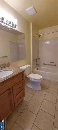 a bathroom with a granite countertop sink a toilet and a mirror