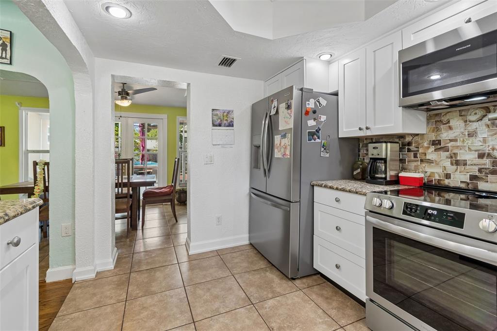 6226 8th Avenue South Gulfport, FL 33707 - Photo 13 of 46 a kitchen with stainless steel appliances granite countertop a refrigerator and a stove top oven