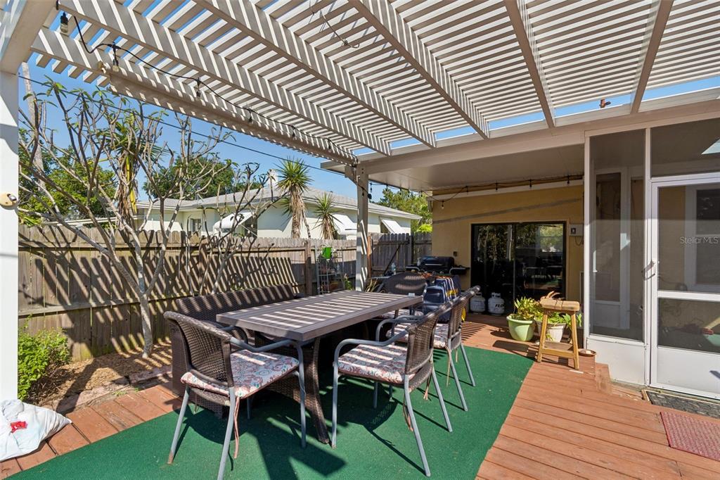 6226 8th Avenue South Gulfport, FL 33707 - Photo 36 of 46 a view of a patio with table and chairs with wooden floor and fence