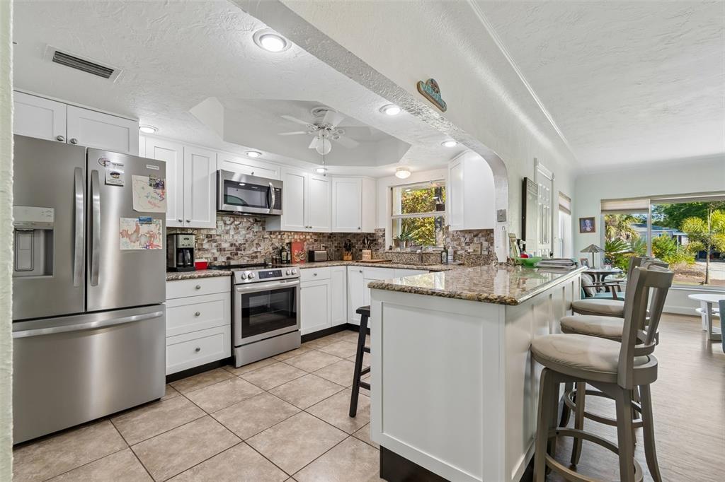 6226 8th Avenue South Gulfport, FL 33707 - Photo 10 of 46 a kitchen with stainless steel appliances white cabinets and a refrigerator
