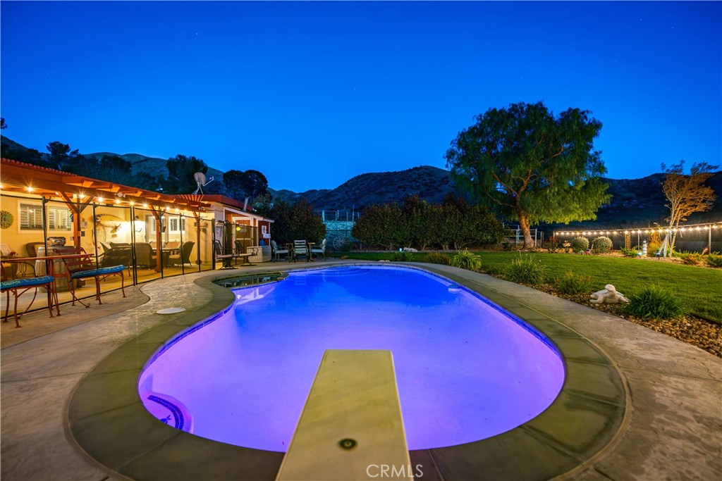 2862 Calmgarden Road Acton, CA 93510 - Photo 43 of 69 a view of a swimming pool with lawn chairs under an umbrella