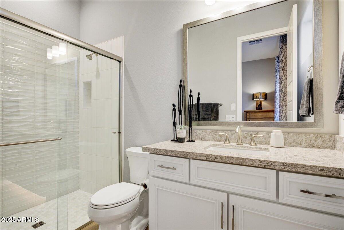 17833 East StockingTrail Rio Verde, AZ 85263 - Photo 26 of 45 a bathroom with a granite countertop sink toilet mirror and shower