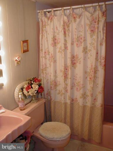 9509 Hall Road Potomac, MD 20854 - Photo 10 of 20 a bathroom with a toilet a sink and curtain