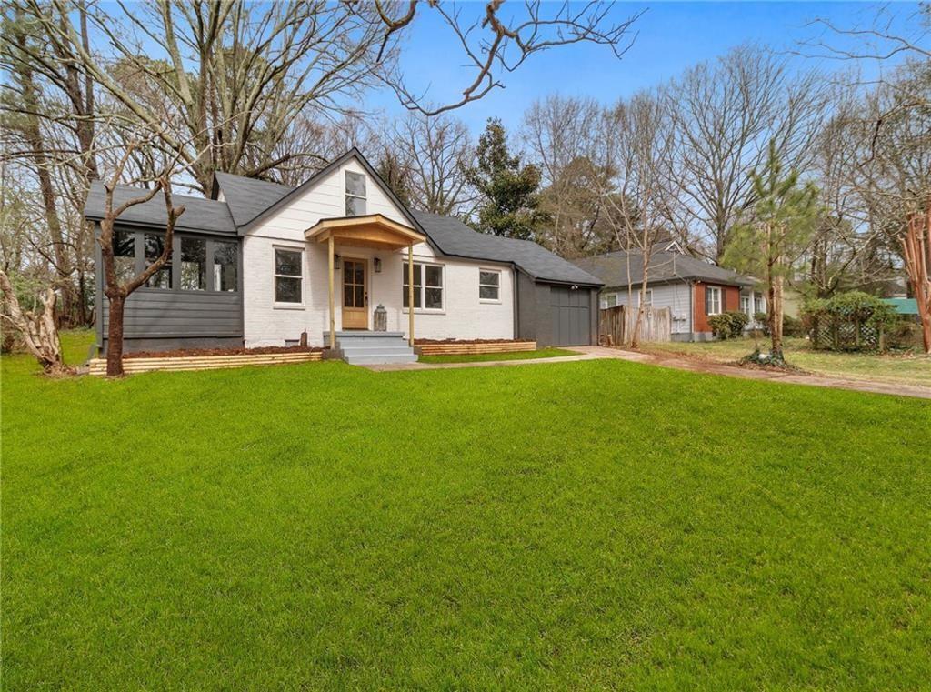 a front view of a house with a yard and trees