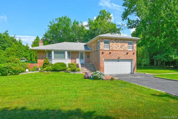 a front view of a house with a yard and trees