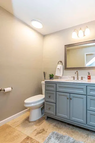 a bathroom with a toilet sink and mirror