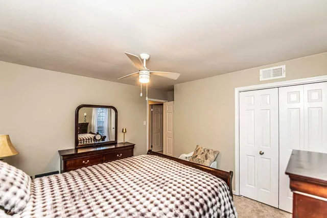 a bedroom with a bed and a lamp on dresser