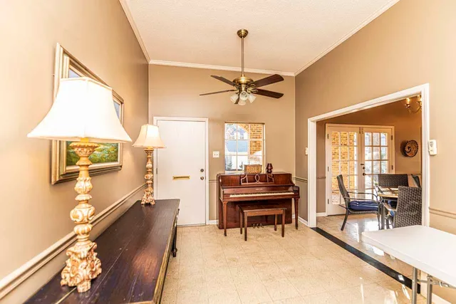 a living room with furniture a piano and a flat screen tv