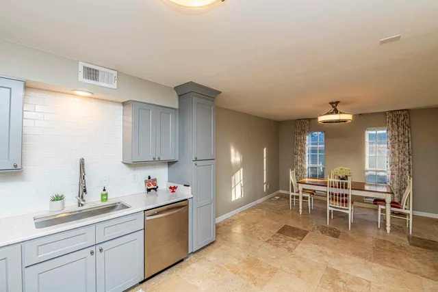 a kitchen with a sink and chairs