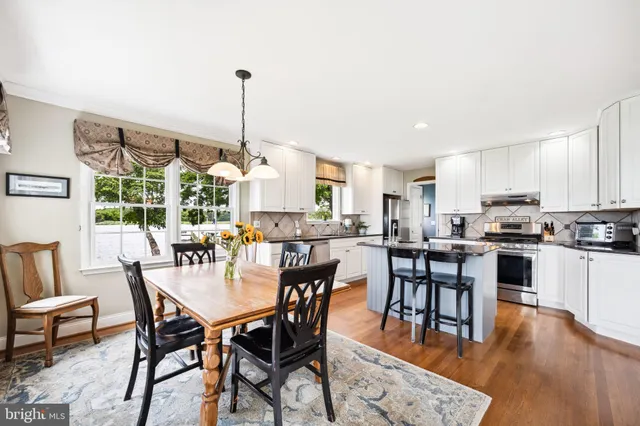a dining room with furniture window and wooden floor
