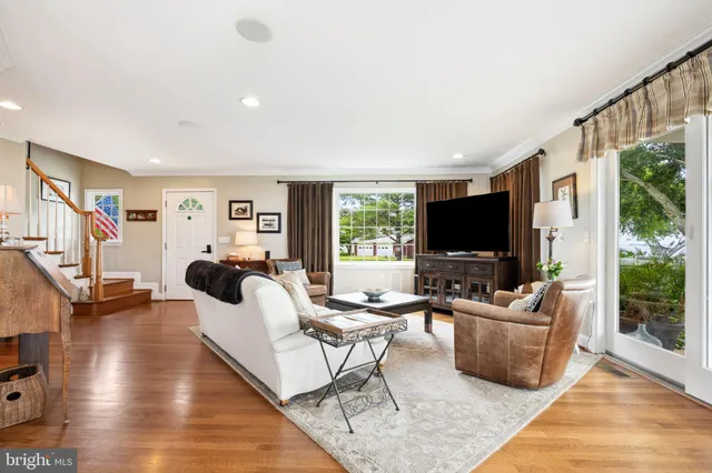 a living room with furniture a flat screen tv and a large window