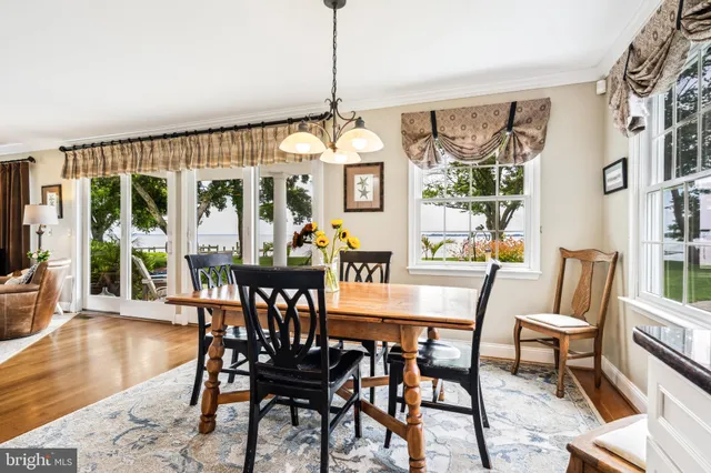 a dining room with furniture a chandelier and wooden floor