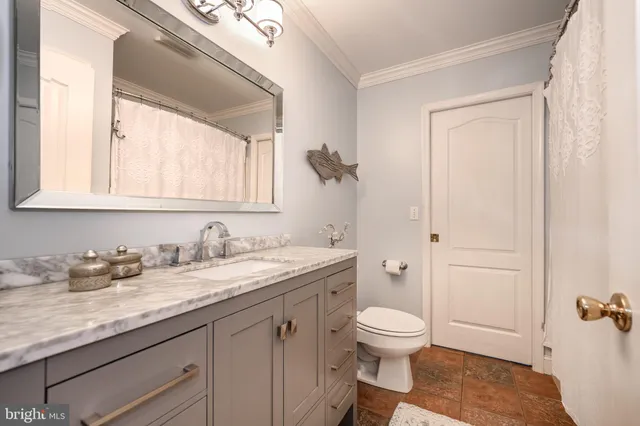 a bathroom with a granite countertop toilet sink and mirror