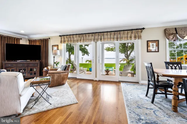 a living room with furniture a flat screen tv and a floor to ceiling window